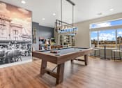 Thumbnail 22 of 30 - A room with a pool table and a picture of a building on the wall.