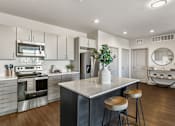 Thumbnail 4 of 30 - A modern kitchen with a large island and stainless steel appliances