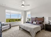 Thumbnail 7 of 30 - A bedroom with a large bed and a ceiling fan.