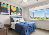 Thumbnail 8 of 30 - A bedroom with a bed, nightstand, and three pictures on the wall.