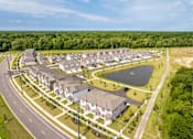 Thumbnail 2 of 26 - A bird's eye view of a residential area with houses and a lake.