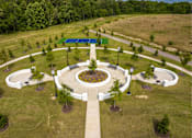 Thumbnail 12 of 26 - A park with a circular walkway and benches.