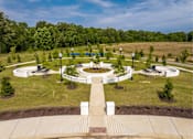 Thumbnail 3 of 26 - A park with a circular walkway and benches.