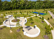 Thumbnail 4 of 26 - A park with a circular white structure and a blue pool in the background.