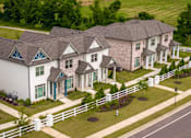 Thumbnail 20 of 26 - A white house with a grey roof and a white fence.