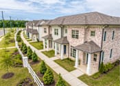 Thumbnail 22 of 26 - A row of houses with white picket fences and green lawns.