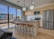 Thumbnail 1 of 35 - A kitchen with a bar area and a refrigerator.