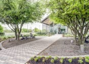 Thumbnail 23 of 26 - a walkway with benches and trees in front of a building