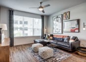 Thumbnail 5 of 26 - a living room with a leather couch and three windows