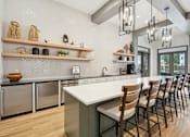 Thumbnail 11 of 34 - A kitchen with a white countertop and wooden chairs.
