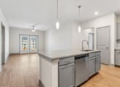 Thumbnail 4 of 34 - A kitchen with a large island and stainless steel appliances.