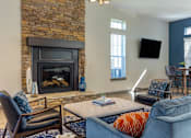 Thumbnail 11 of 29 - A living room with a fireplace and a blue couch.
