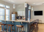 Thumbnail 12 of 29 - A kitchen with a bar area and stools.