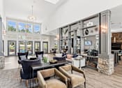 Thumbnail 8 of 29 - A residential clubhouse with chairs, tables, and a couch at Parkstone at Knightdale apartments for rent in Knightdale, NC.