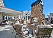 Thumbnail 23 of 29 - A patio with chairs and a fireplace.