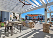 Thumbnail 25 of 29 - A patio with a table and chairs under a white canopy.