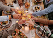 Thumbnail 16 of 59 - a group of people raising their glasses over a dinner table