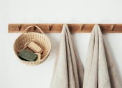 Thumbnail 23 of 59 - a wooden shelf with two towels and a basket on it