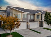 Thumbnail 18 of 21 - A modern house with a grey roof and a white garage door.