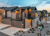 Thumbnail 22 of 26 - A row of modern houses with garages and driveways.