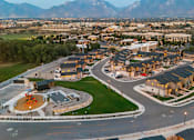 Thumbnail 25 of 26 - A cityscape with a large open space in the foreground and mountains in the background.
