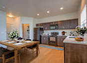 Thumbnail 3 of 21 - A modern kitchen with a dining table set for two.