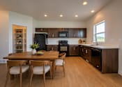 Thumbnail 1 of 21 - A kitchen with a table and chairs in the middle of the room.