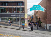 Thumbnail 12 of 18 - people walking down the street in front of a building with a sign that says post alley