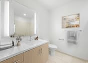 Thumbnail 56 of 58 - A bathroom with a toilet, sink, and mirror.