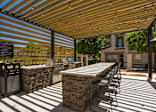 Thumbnail 14 of 38 - a patio with tables and chairs under a wooden roof