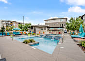 Thumbnail 9 of 28 - A swimming pool with a waterfall and a building in the background.