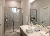 Thumbnail 22 of 28 - a bathroom with a shower and a sink and a mirror