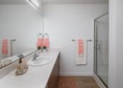 Thumbnail 9 of 27 - A bathroom with a sink, mirror, and towel hanging on the door at The Arvon, Vancouver, WA 98662