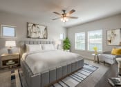 Thumbnail 13 of 31 - a bedroom with a large bed and a ceiling fan