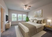 Thumbnail 17 of 31 - a bedroom with a large bed and a ceiling fan