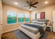 Thumbnail 27 of 28 - a bedroom with a bed and a ceiling fan