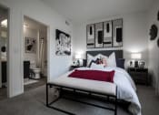 Thumbnail 4 of 24 - a bedroom with a large bed and a bathroom in the background