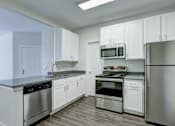 Thumbnail 45 of 45 - A kitchen with white cabinets and stainless steel appliances.