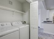 Thumbnail 8 of 45 - A white laundry room with a washer and dryer.