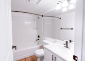 Thumbnail 27 of 27 - A white bathroom with a toilet, sink, and bathtub.