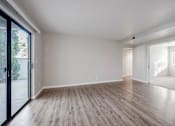 Thumbnail 24 of 27 - A spacious room with wooden flooring and white walls.