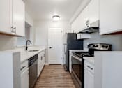 Thumbnail 23 of 27 - A kitchen with white cabinets and appliances.