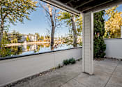 Thumbnail 10 of 27 - A patio with a view of a lake and trees.