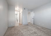 Thumbnail 26 of 27 - A spacious, empty room with carpeted floor and white walls.