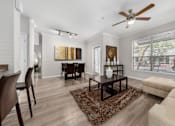 Thumbnail 1 of 25 - A living room with a brown rug and a brown coffee table.