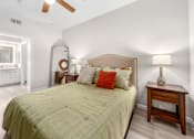 Thumbnail 5 of 25 - A bedroom with a bed, nightstand, and a ceiling fan.