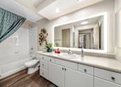 Thumbnail 7 of 25 - A bathroom with a white sink and a white toilet.