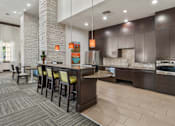 Thumbnail 14 of 25 - A modern kitchen with a bar area and a dining table.