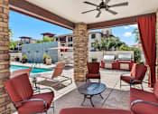 Thumbnail 20 of 25 - A patio with red chairs and a table.