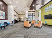 Thumbnail 6 of 12 - A modern office lounge with a variety of seating options and a colorful mural on the wall.